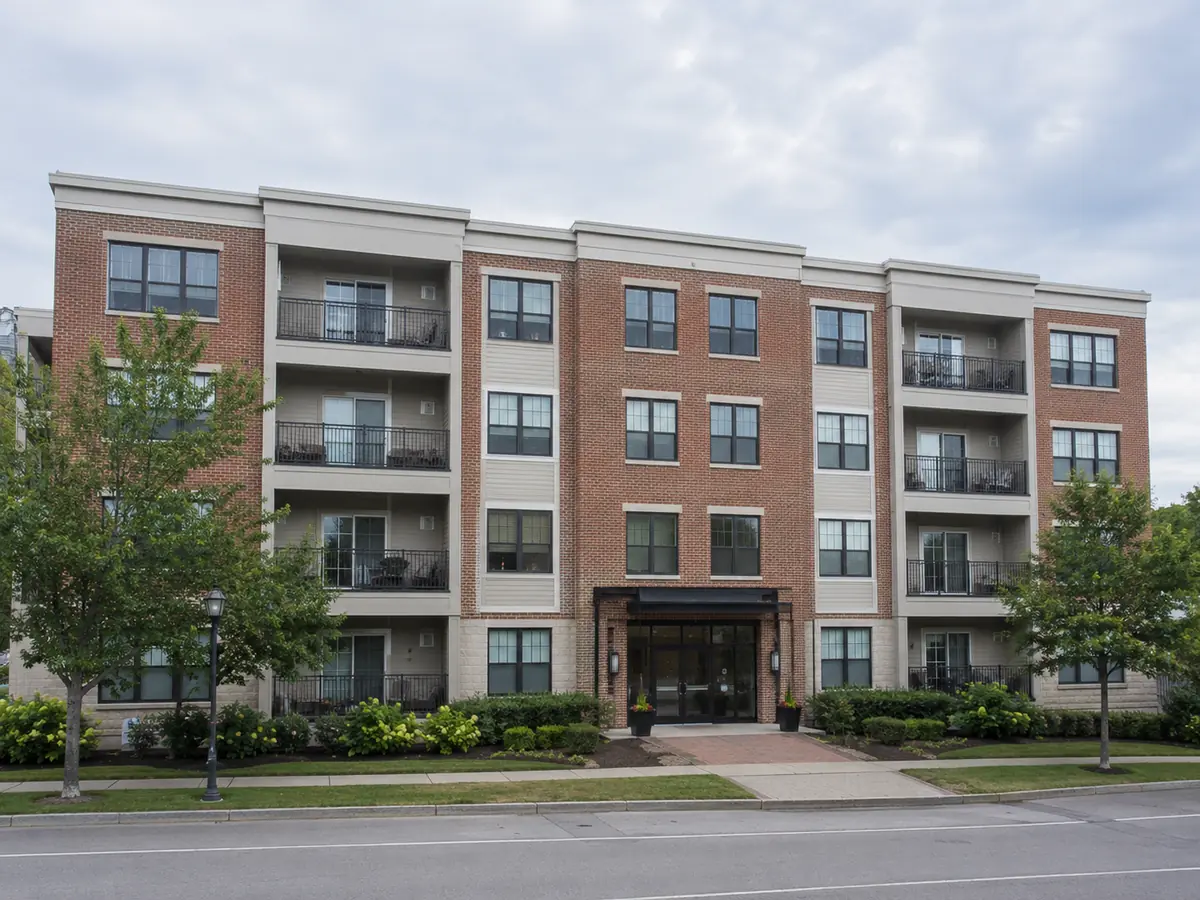 Mid-size four-story apartment building with brick facade and balconies