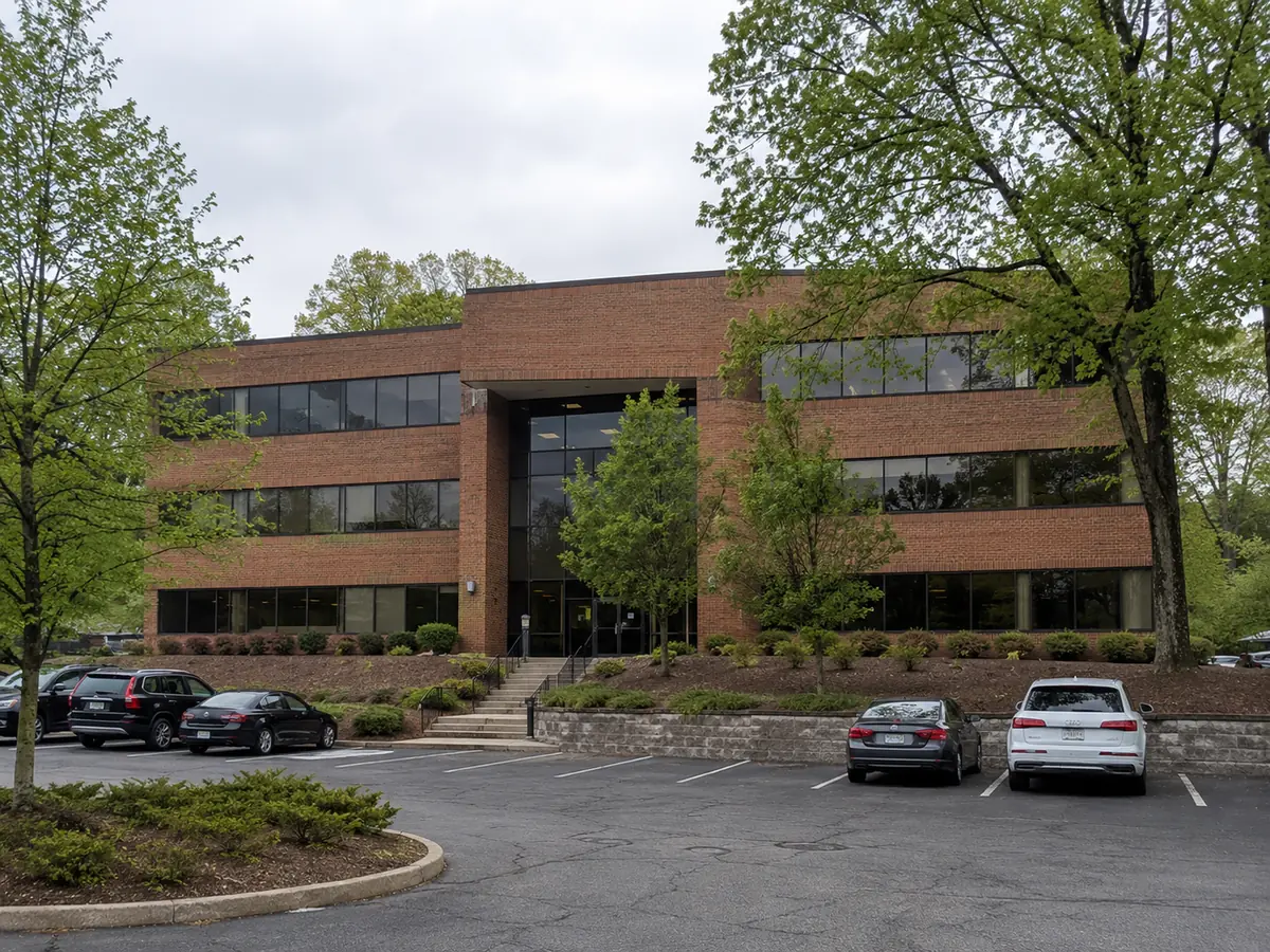 Suburban multi-tenant office building with brick and glass facade and surface parking
